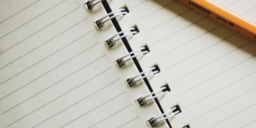 white notebook with pencil