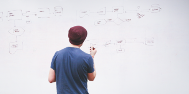 man creating strategy on whiteboard