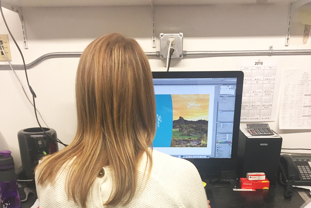 production artist designing graphics on computer